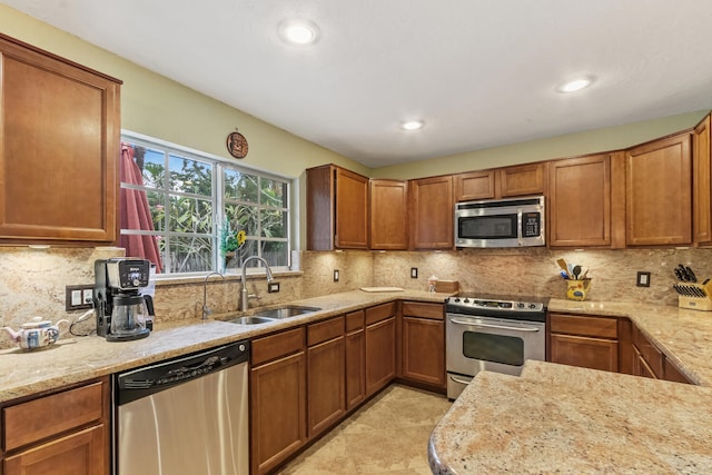 kitchen with light stone countertops, sink, decorative backsplash, light tile patterned flooring, and appliances with stainless steel finishes