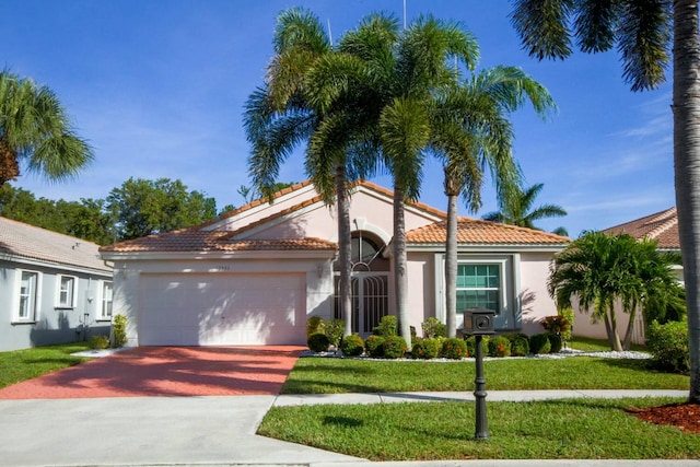 mediterranean / spanish-style house featuring a front lawn and a garage