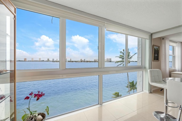 sunroom featuring a water view