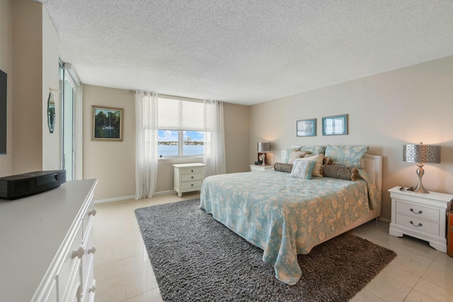 bedroom with light tile patterned floors and a textured ceiling