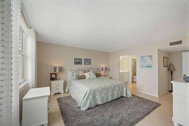 bedroom with a textured ceiling and ensuite bath