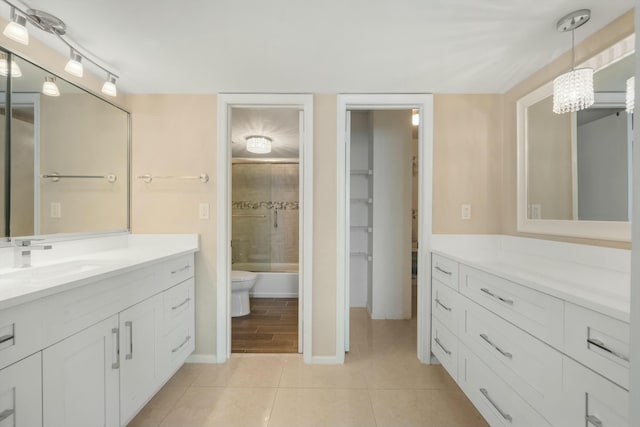 full bathroom featuring combined bath / shower with glass door, vanity, tile patterned flooring, and toilet