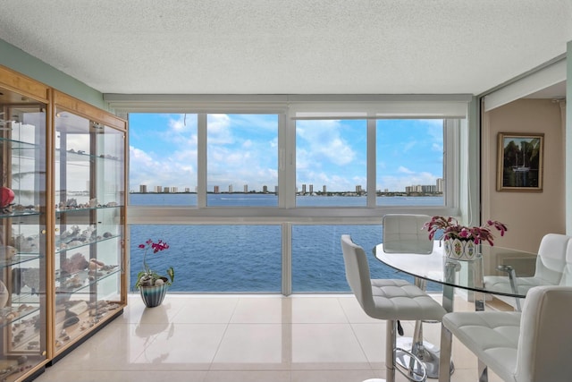 sunroom featuring a water view