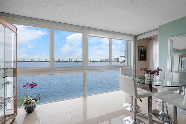 sunroom featuring a water view