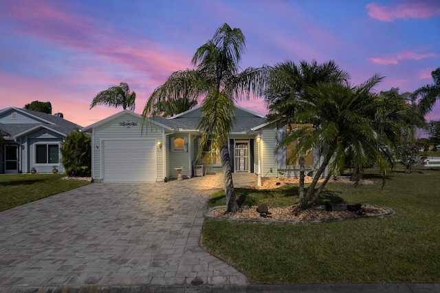 view of front of home with a yard and a garage