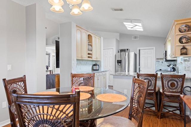 dining room featuring lofted ceiling, light hardwood / wood-style flooring, and a chandelier