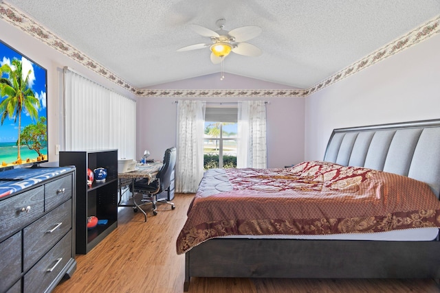 bedroom with a textured ceiling, light hardwood / wood-style flooring, ceiling fan, and lofted ceiling