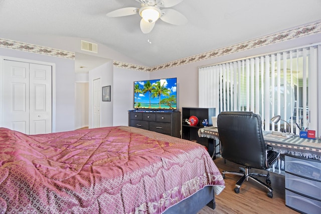 bedroom with hardwood / wood-style floors, a closet, ceiling fan, and lofted ceiling