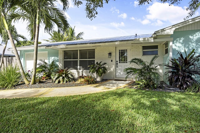 ranch-style house featuring a front yard and a garage