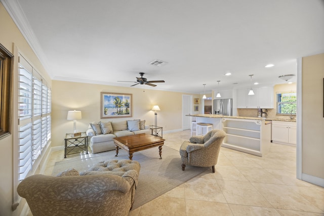 tiled living room with ceiling fan, sink, and crown molding