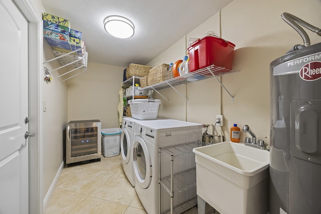 washroom with electric water heater, sink, wine cooler, washing machine and dryer, and light tile patterned floors