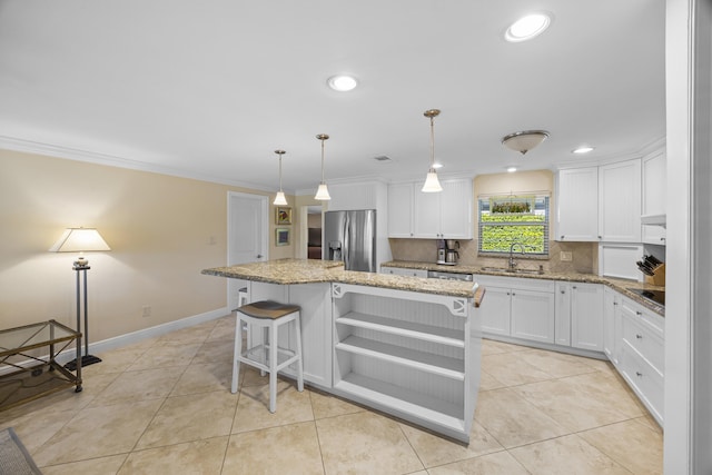 kitchen featuring stainless steel refrigerator with ice dispenser, backsplash, sink, white cabinets, and a kitchen island