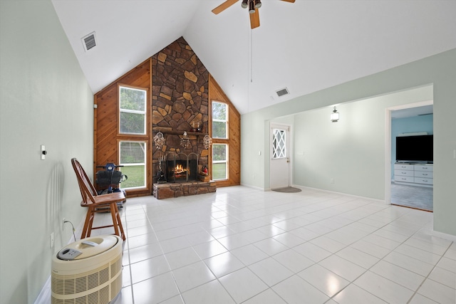 unfurnished living room featuring ceiling fan, light tile patterned flooring, a fireplace, and high vaulted ceiling