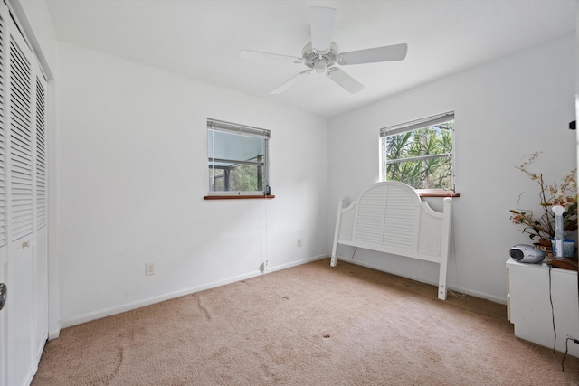 unfurnished bedroom featuring ceiling fan, a closet, and light carpet