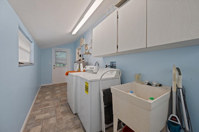 washroom featuring washing machine and clothes dryer, sink, and cabinets