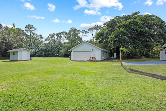 view of yard featuring a garage and a storage unit