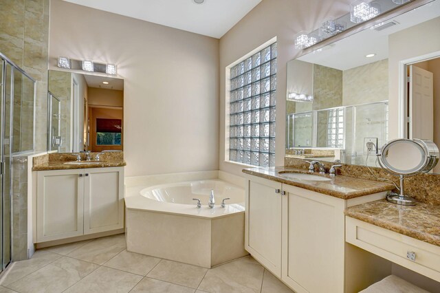 bathroom featuring tile patterned flooring, shower with separate bathtub, and vanity