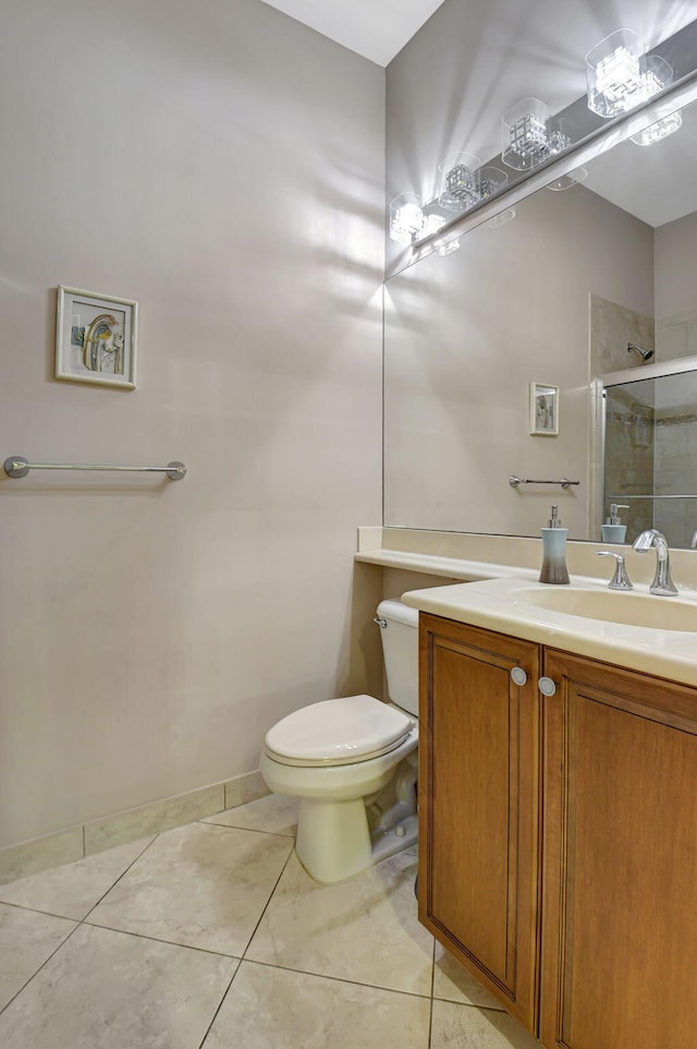 bathroom featuring tile patterned floors, vanity, toilet, and walk in shower