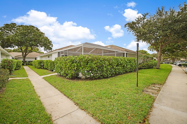 view of home's exterior featuring a lanai and a lawn