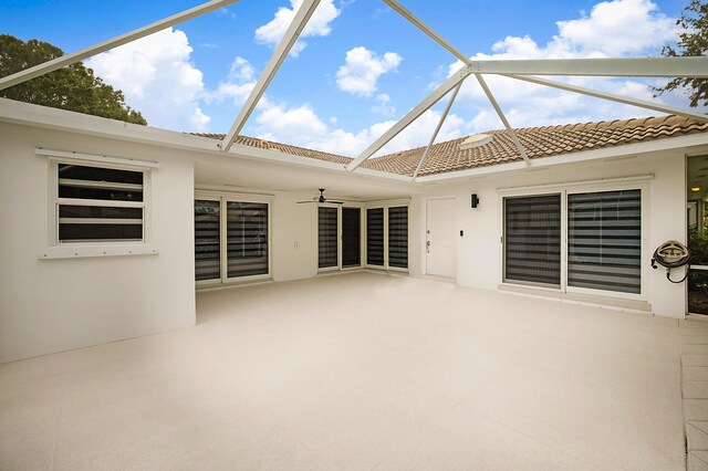 unfurnished sunroom with ceiling fan