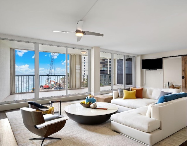 living room with hardwood / wood-style flooring, ceiling fan, and a water view