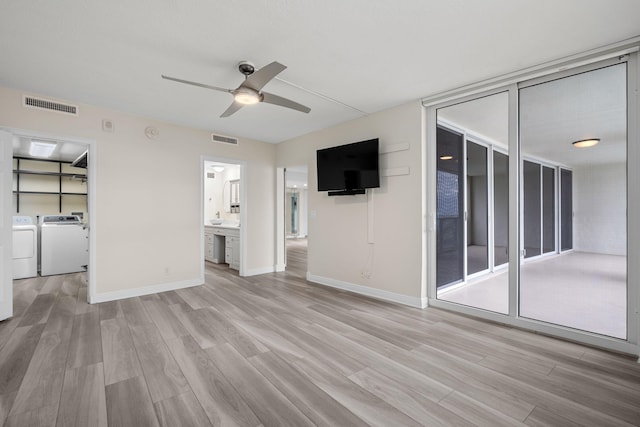 unfurnished living room with ceiling fan, washer and clothes dryer, and light hardwood / wood-style flooring