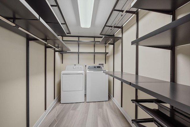 laundry room featuring washer and dryer and light wood-type flooring