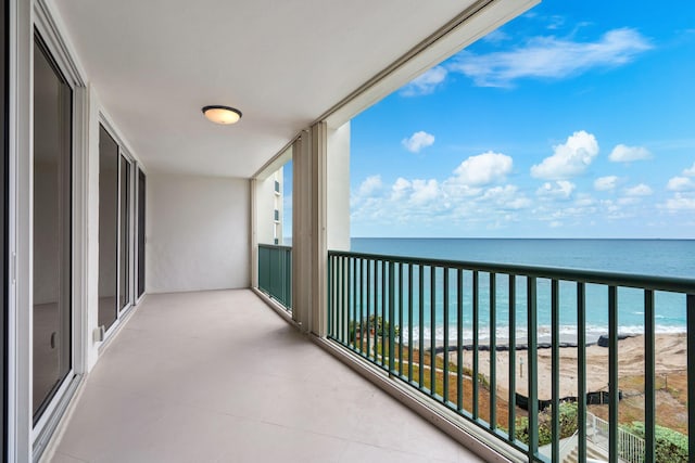 balcony with a water view and a beach view