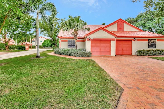 mediterranean / spanish house featuring a front lawn and a garage