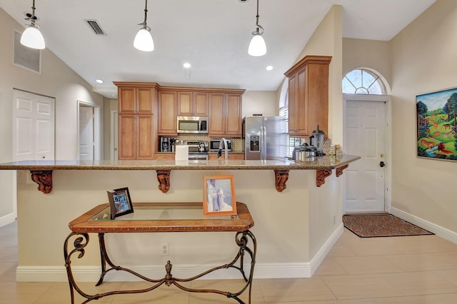 kitchen with pendant lighting, a breakfast bar, and appliances with stainless steel finishes