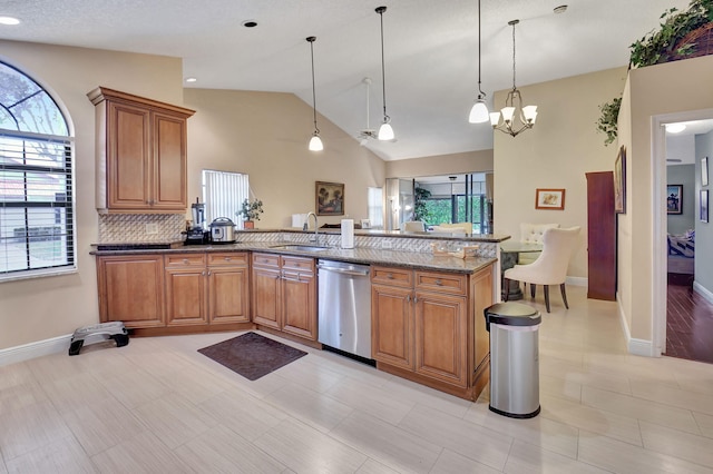 kitchen with stone counters, dishwasher, a notable chandelier, pendant lighting, and lofted ceiling