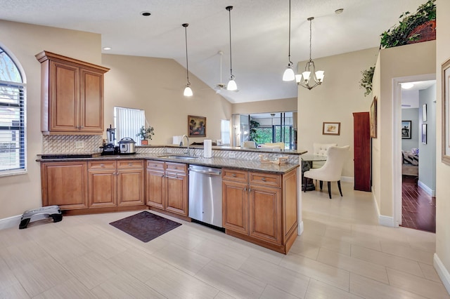 kitchen featuring dishwasher, sink, hanging light fixtures, a notable chandelier, and dark stone counters