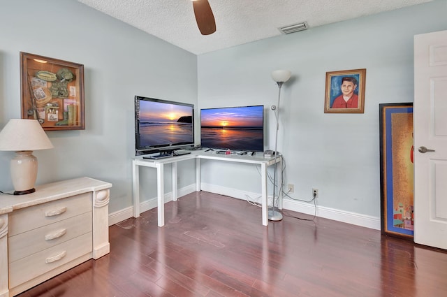 office area with a textured ceiling, ceiling fan, and dark wood-type flooring