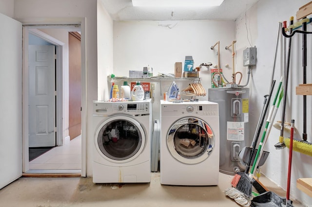 laundry room with electric water heater, a textured ceiling, and washing machine and clothes dryer