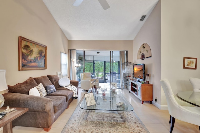 living room featuring a textured ceiling, high vaulted ceiling, and ceiling fan