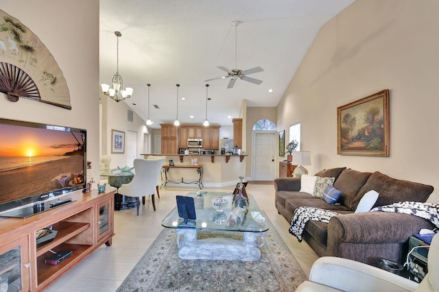 living room with high vaulted ceiling and ceiling fan with notable chandelier