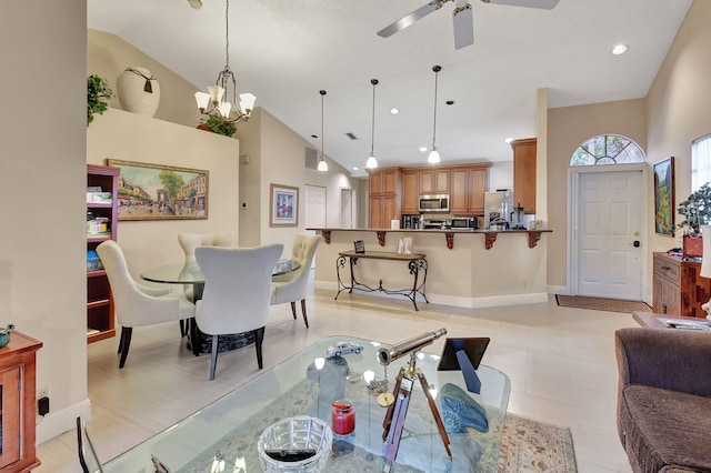 tiled dining room with ceiling fan with notable chandelier and high vaulted ceiling