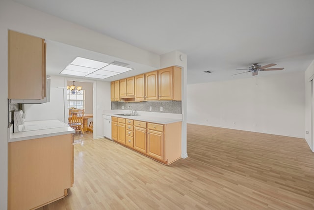 kitchen featuring a skylight, sink, light brown cabinets, decorative backsplash, and light wood-type flooring