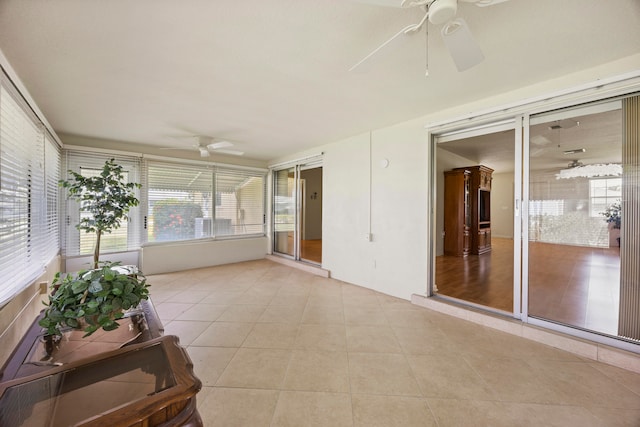 unfurnished sunroom with ceiling fan