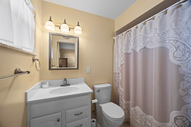 bathroom with a shower with shower curtain, vanity, and toilet