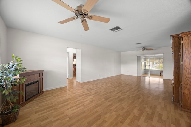 unfurnished living room featuring a textured ceiling, light hardwood / wood-style flooring, and ceiling fan