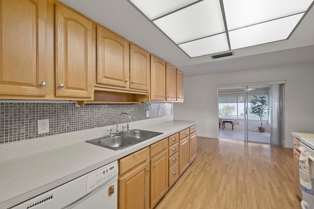 kitchen with white dishwasher, sink, decorative backsplash, light wood-type flooring, and light brown cabinetry