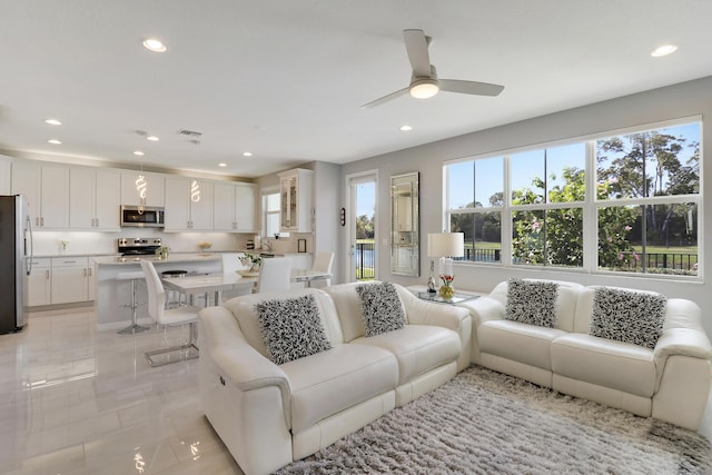 living room with ceiling fan, a healthy amount of sunlight, light tile patterned flooring, and sink