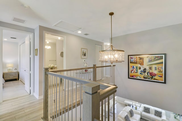 corridor with a chandelier and light hardwood / wood-style floors