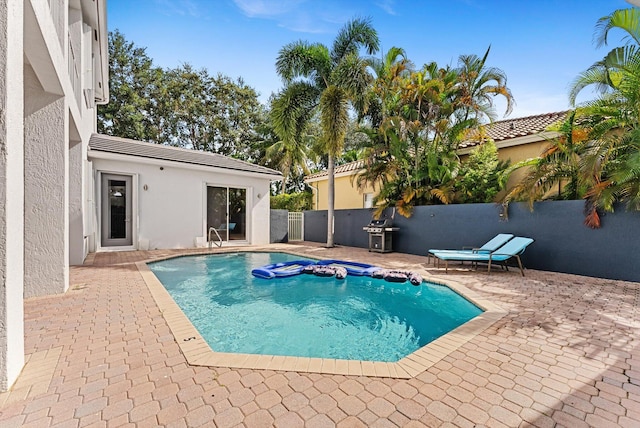 view of pool featuring a patio and grilling area