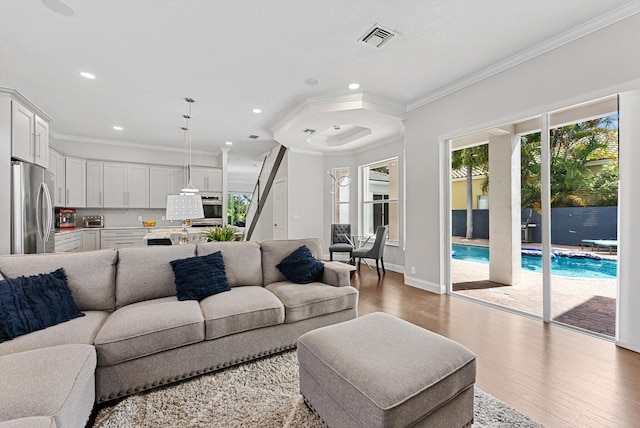 living room featuring light hardwood / wood-style floors and crown molding