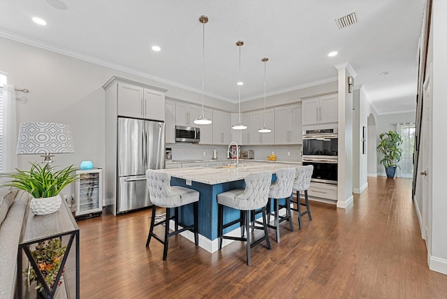 kitchen with hanging light fixtures, a breakfast bar, dark hardwood / wood-style flooring, and stainless steel appliances