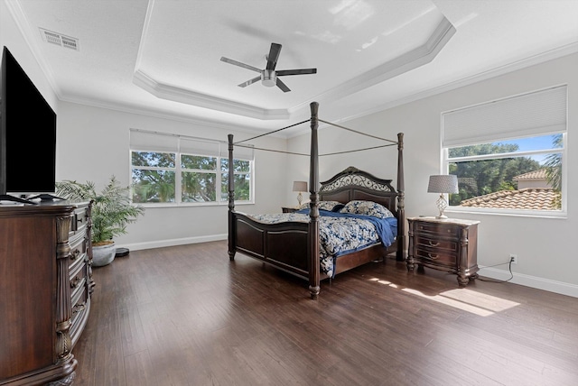 bedroom with a tray ceiling, ceiling fan, dark hardwood / wood-style flooring, and crown molding