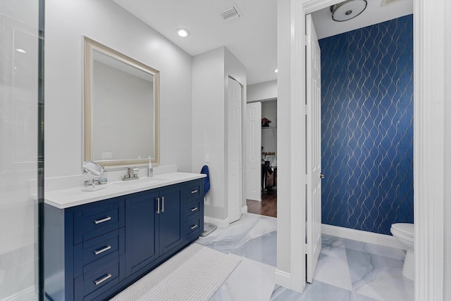 bathroom with vanity, toilet, and tile walls