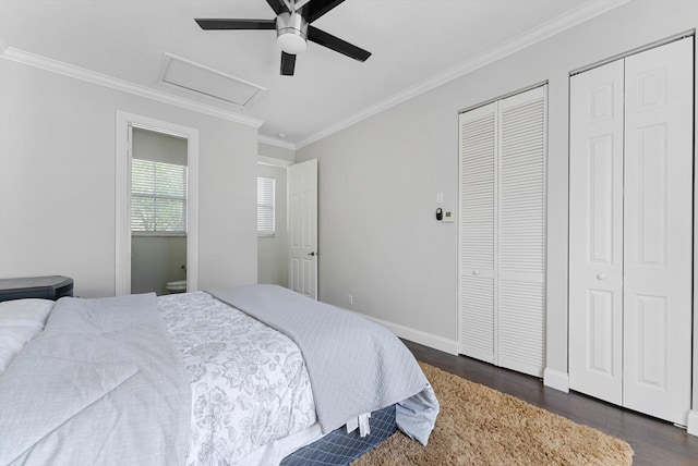 bedroom featuring ceiling fan, crown molding, dark wood-type flooring, and two closets